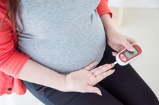 Pregnant woman measuring her blood glucose.