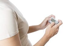 Bir kadın bir insülin pompasını ellerinde tutuyor.