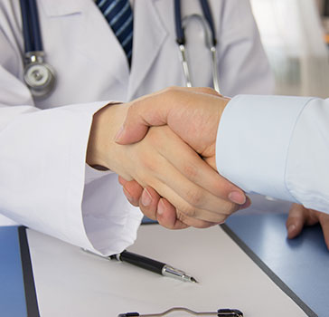 Arzt schüttelt Patient die Hand